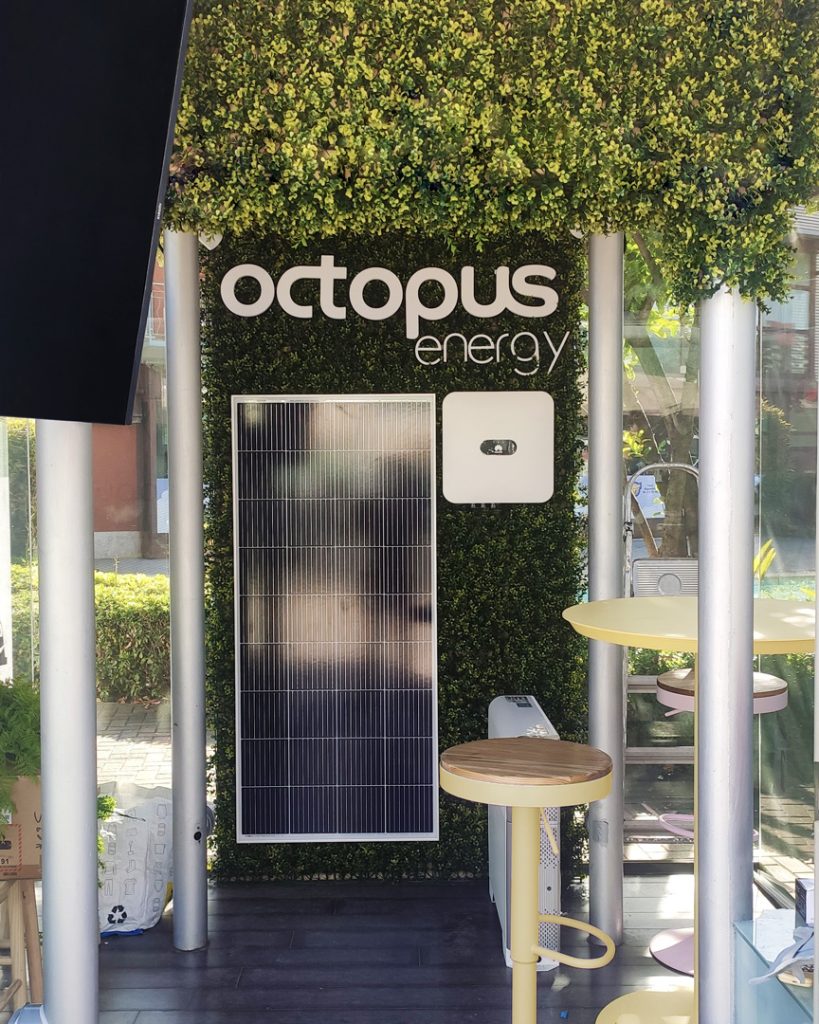 03-DISEÑO-OCTOPUS-ENERGY-REBEL-CAPYBARA Imagen de panel solar sobre vegetación en puesto de información de Octopus Energy.Por Rebel Capybara Studio.